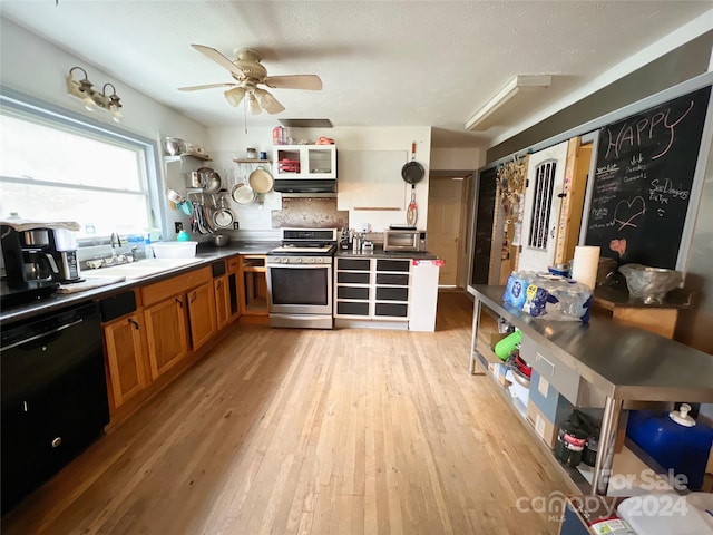 kitchen featuring sink, stainless steel range, black dishwasher, range hood, and light hardwood / wood-style floors