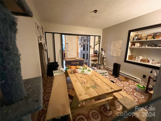 bedroom featuring a textured ceiling and a baseboard heating unit