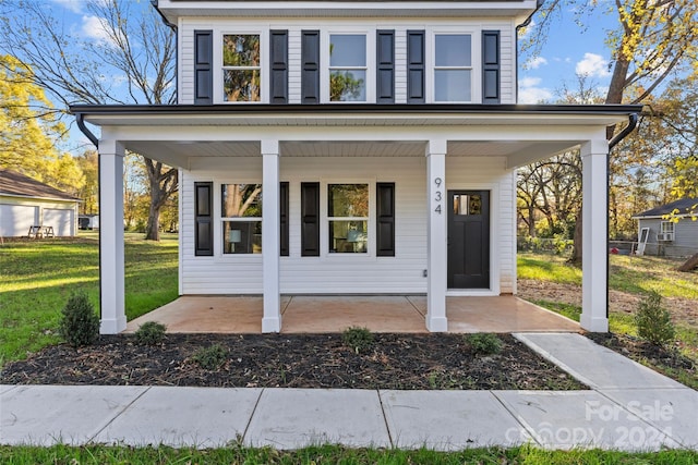 view of front of property with covered porch and a front yard