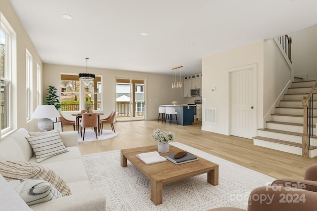 living room featuring a notable chandelier and light hardwood / wood-style flooring