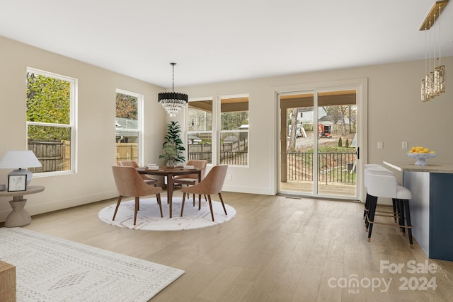 dining space with an inviting chandelier and light wood-type flooring