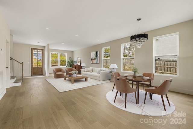 dining space featuring a chandelier, a healthy amount of sunlight, and light hardwood / wood-style flooring