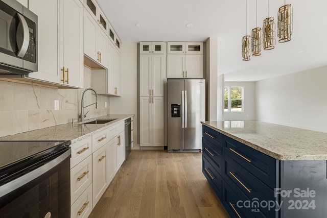 kitchen with white cabinetry, sink, blue cabinets, light hardwood / wood-style floors, and appliances with stainless steel finishes