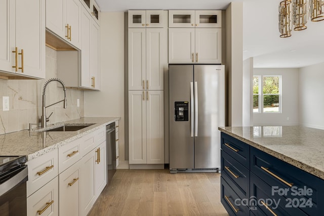 kitchen with blue cabinetry, sink, white cabinets, and stainless steel appliances