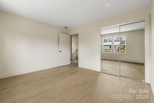 unfurnished bedroom featuring a closet and light wood-type flooring