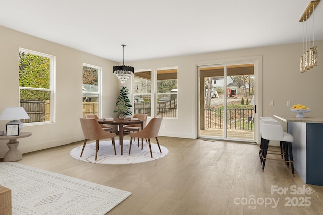 65 Bellevue Rd Unit 3, Asheville, NC 28803 - dining area featuring a chandelier, light wood-type flooring, and baseboards