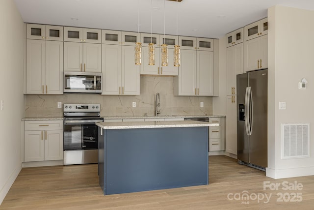 65 Bellevue Rd Unit 3, Asheville, NC 28803 - kitchen with stainless steel appliances, a sink, a kitchen island, light wood finished floors, and decorative backsplash