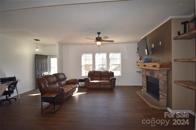 living room with a stone fireplace, ceiling fan, dark hardwood / wood-style flooring, and ornamental molding