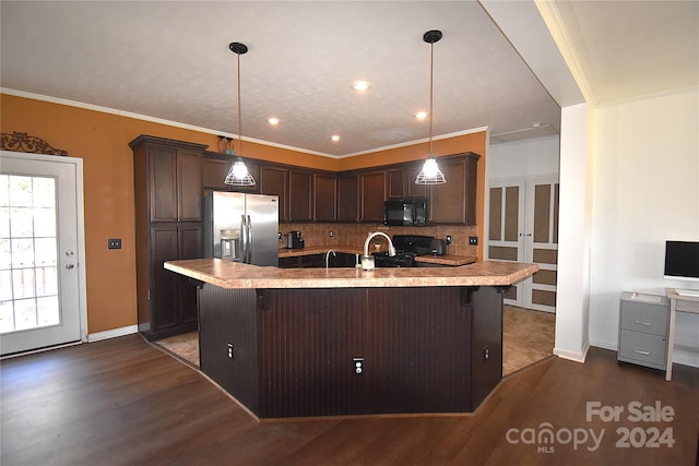 kitchen with hanging light fixtures, an island with sink, and black appliances