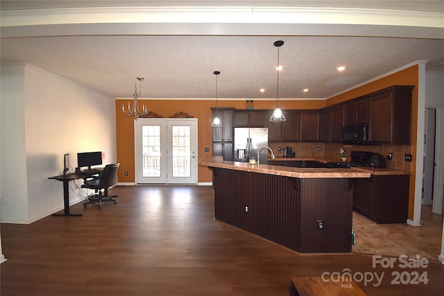 kitchen featuring pendant lighting, black appliances, a center island with sink, dark hardwood / wood-style floors, and a chandelier