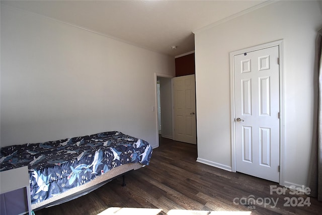 bedroom featuring crown molding and dark wood-type flooring