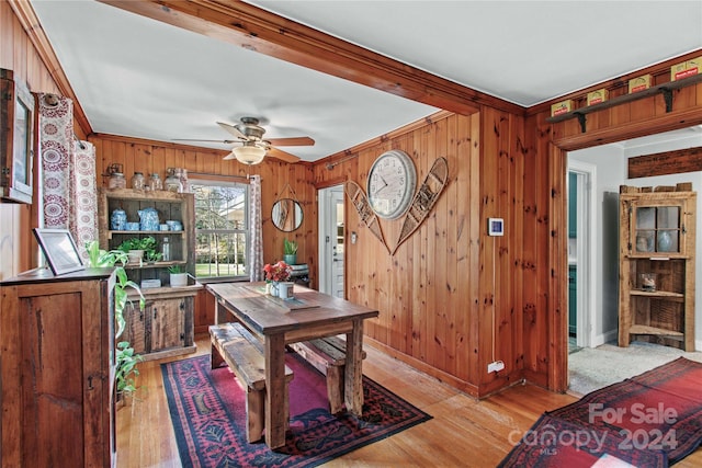 office featuring beam ceiling, wooden walls, crown molding, and light hardwood / wood-style floors