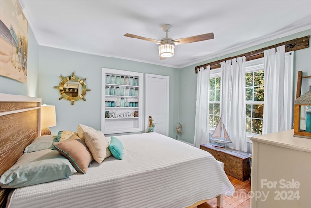 bedroom with hardwood / wood-style floors, ceiling fan, and ornamental molding