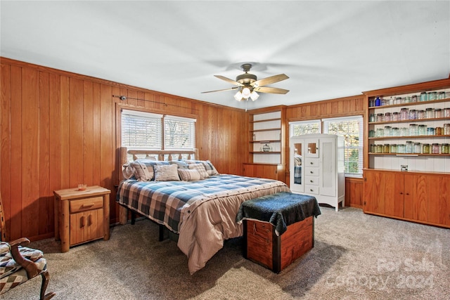 bedroom with multiple windows, wooden walls, and ceiling fan