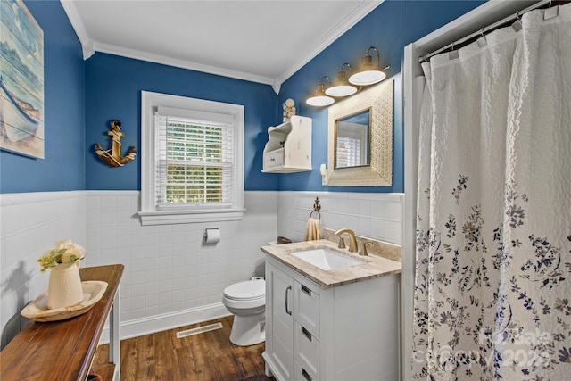 bathroom featuring vanity, hardwood / wood-style flooring, toilet, ornamental molding, and walk in shower