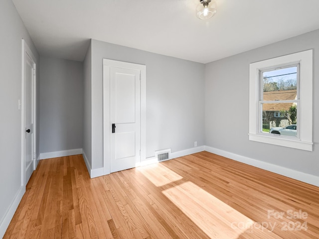 unfurnished bedroom with a closet and light hardwood / wood-style flooring