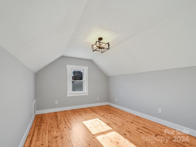 bonus room featuring vaulted ceiling and hardwood / wood-style flooring