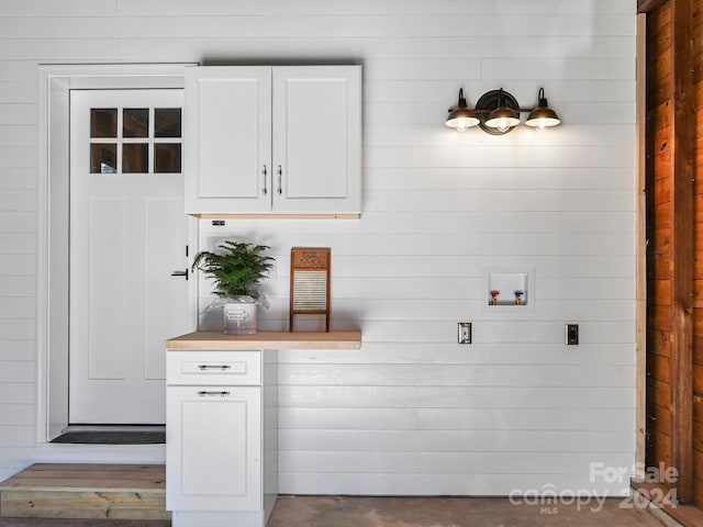 laundry room featuring cabinets, washer hookup, hookup for an electric dryer, and wood walls