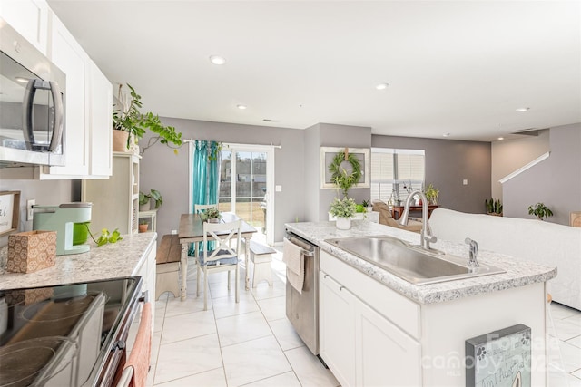 kitchen with sink, an island with sink, white cabinets, and appliances with stainless steel finishes