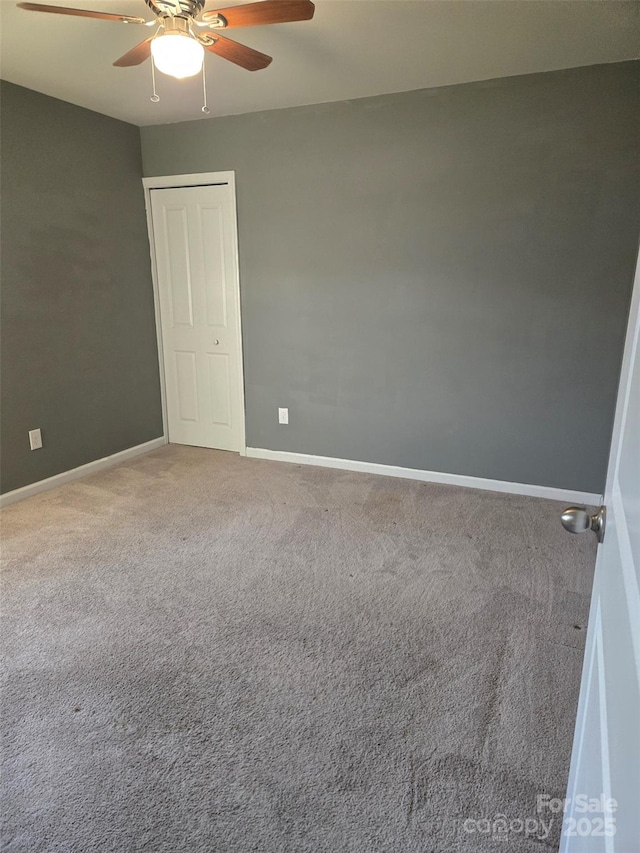 unfurnished room featuring ceiling fan and carpet flooring