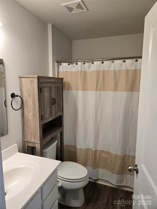 bathroom with wood-type flooring, toilet, and vanity