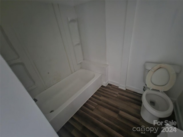 bathroom featuring hardwood / wood-style floors, toilet, and a bathtub