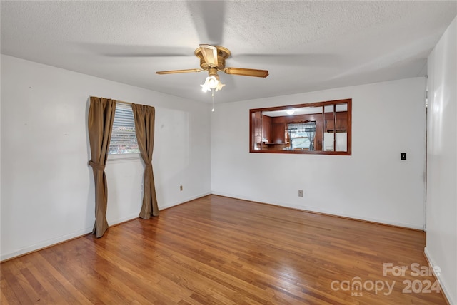 unfurnished room with a textured ceiling, light hardwood / wood-style flooring, and ceiling fan