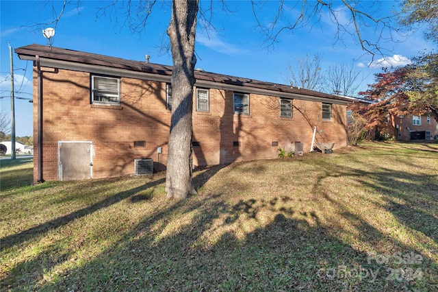 back of property with a yard and central AC unit