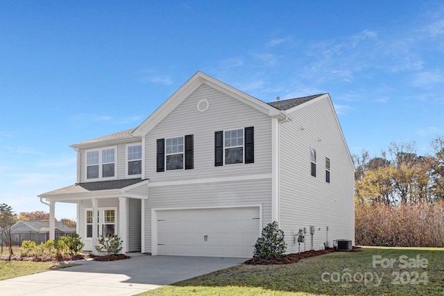 view of front property featuring central air condition unit, a front lawn, and a garage