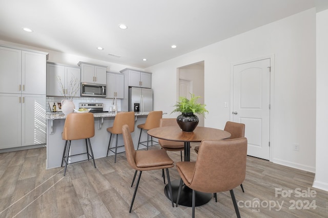 dining area with light wood-type flooring and sink