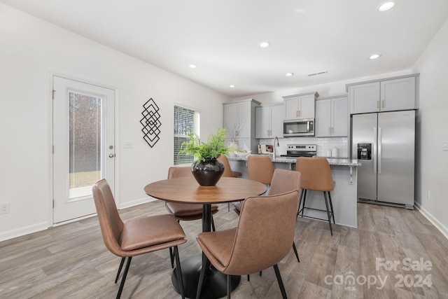 dining room featuring sink and light hardwood / wood-style floors