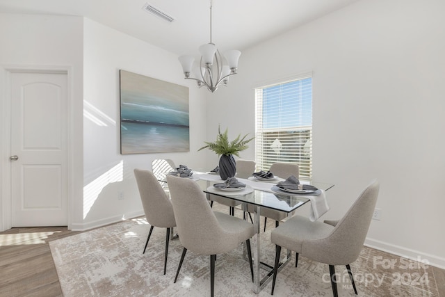 dining area featuring hardwood / wood-style floors and a notable chandelier