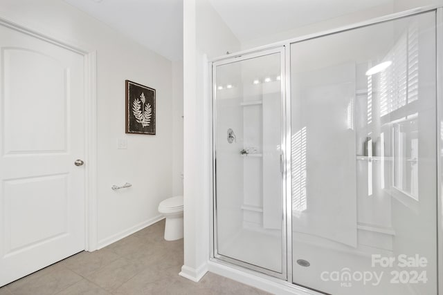 bathroom featuring tile patterned floors, a shower with shower door, and toilet