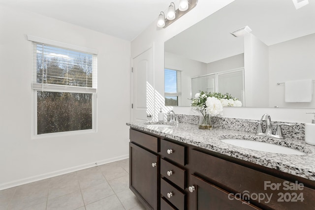 bathroom with tile patterned flooring, vanity, and a shower with shower door