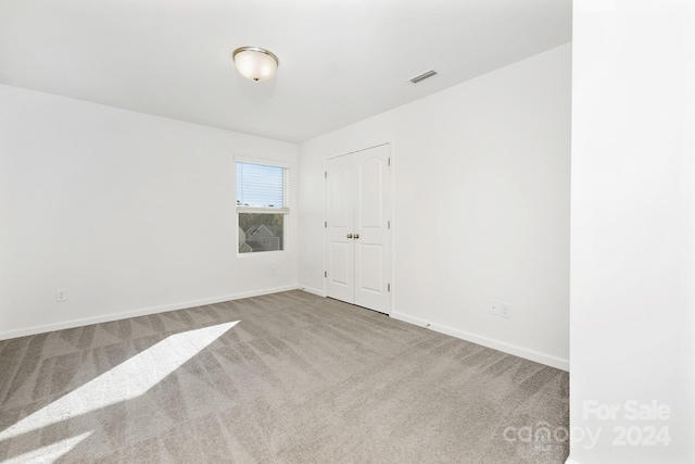 unfurnished room featuring light carpet