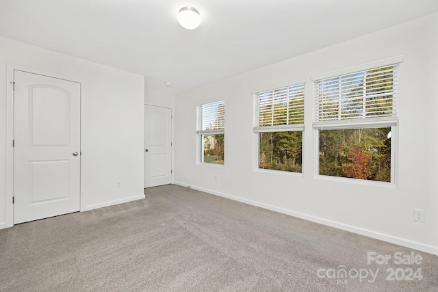 unfurnished room featuring light carpet