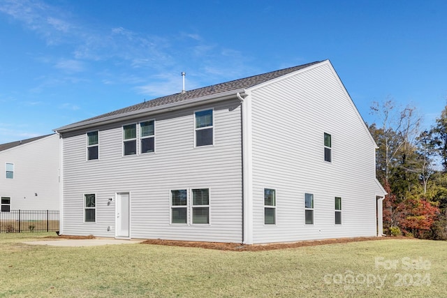 rear view of property featuring a yard