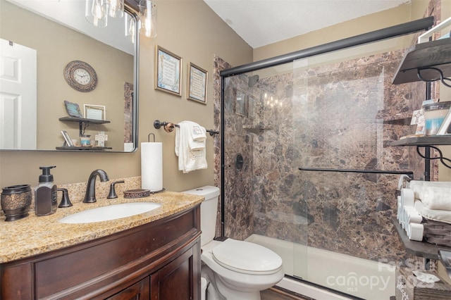 bathroom featuring vanity, toilet, and an enclosed shower