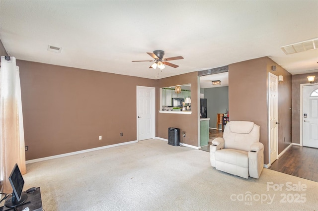 living area featuring ceiling fan and carpet floors