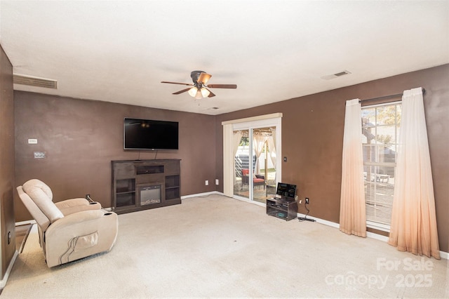 carpeted living room with ceiling fan