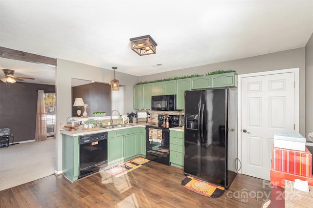 kitchen featuring green cabinets, sink, black appliances, and decorative light fixtures