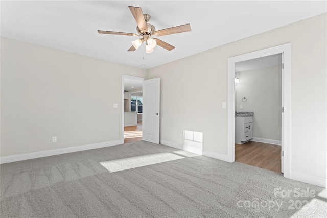 unfurnished bedroom with ceiling fan, ensuite bathroom, and light carpet