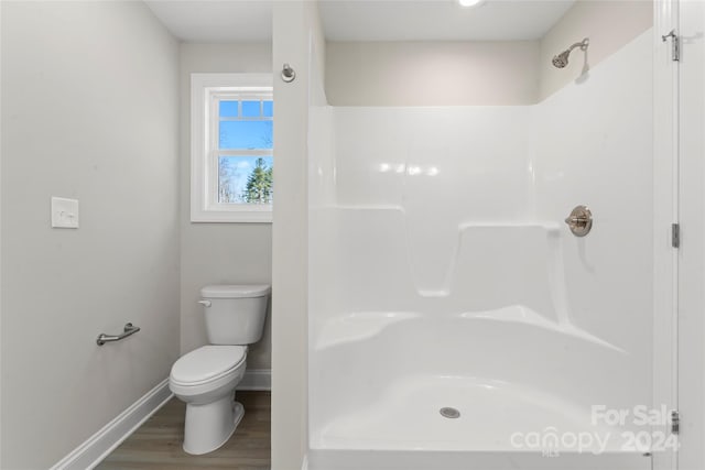 bathroom with a shower, hardwood / wood-style floors, and toilet