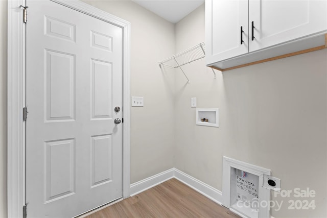 washroom featuring cabinets, hookup for a washing machine, light hardwood / wood-style flooring, and electric dryer hookup