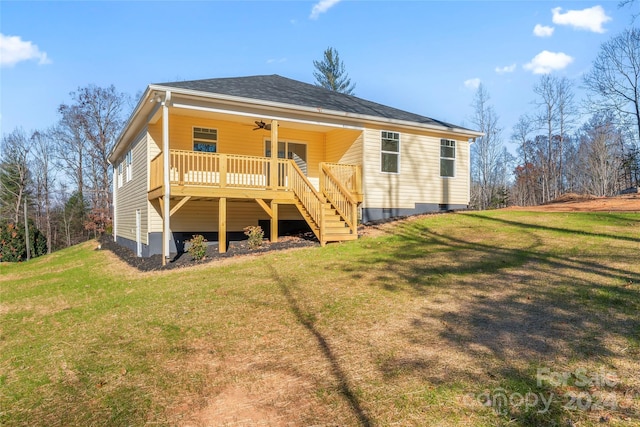 back of property with ceiling fan and a lawn