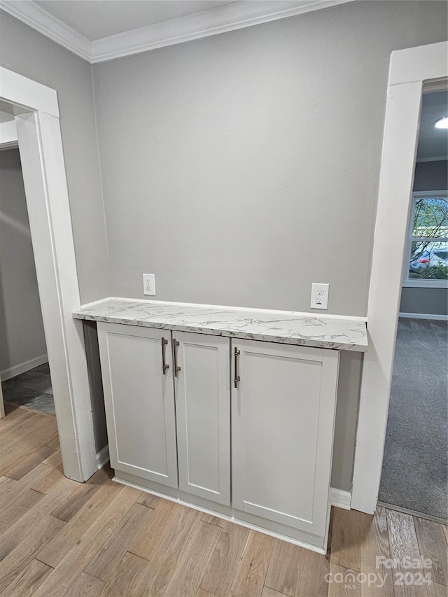 interior details featuring wood-type flooring and crown molding