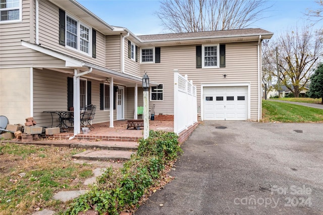 view of property featuring a porch and a garage