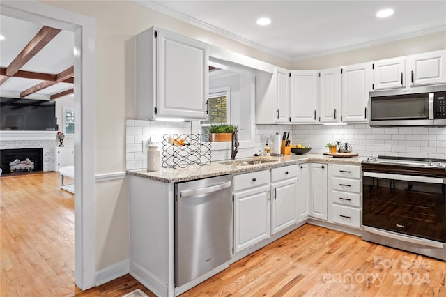 kitchen with backsplash, sink, white cabinetry, and stainless steel appliances