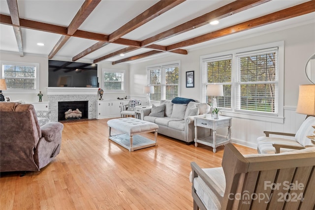 living room with plenty of natural light, beamed ceiling, and light hardwood / wood-style floors