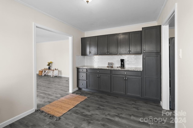 kitchen with decorative backsplash, crown molding, light stone countertops, and dark wood-type flooring